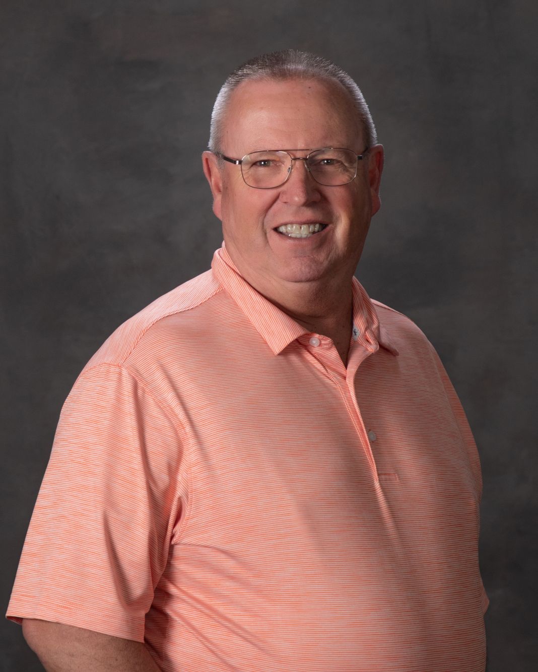 Man with glasses and peach shirt