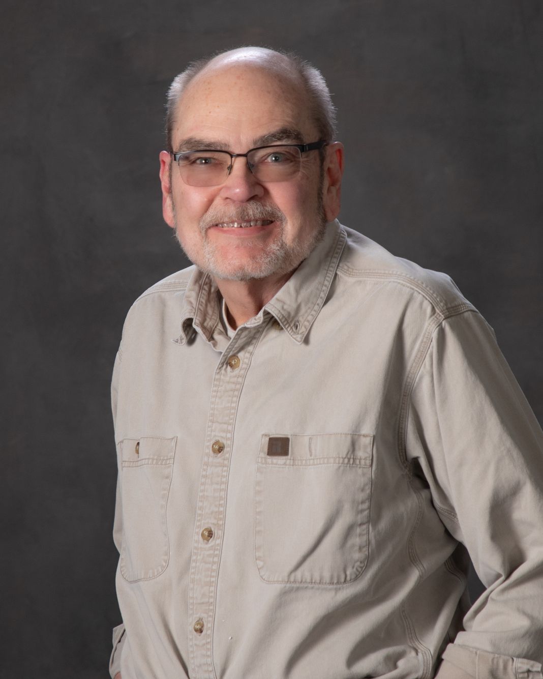 Man with glasses in tan shirt