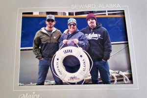 A woman and two men on a ship in Seward, Alaska