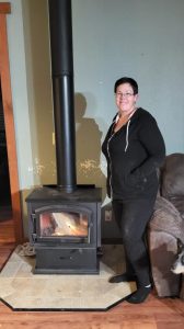 Woman standing by a fireplace