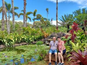 A couple sitting by a tropical pond